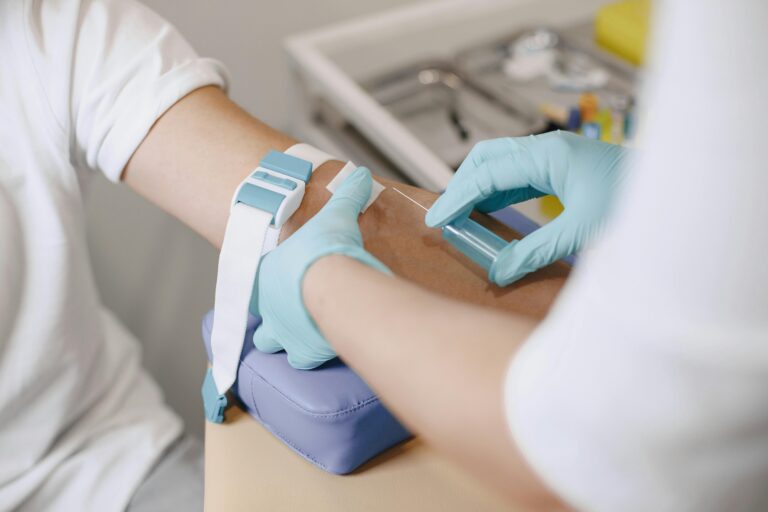 Close-up of a healthcare professional drawing blood from a patient in a medical setting.